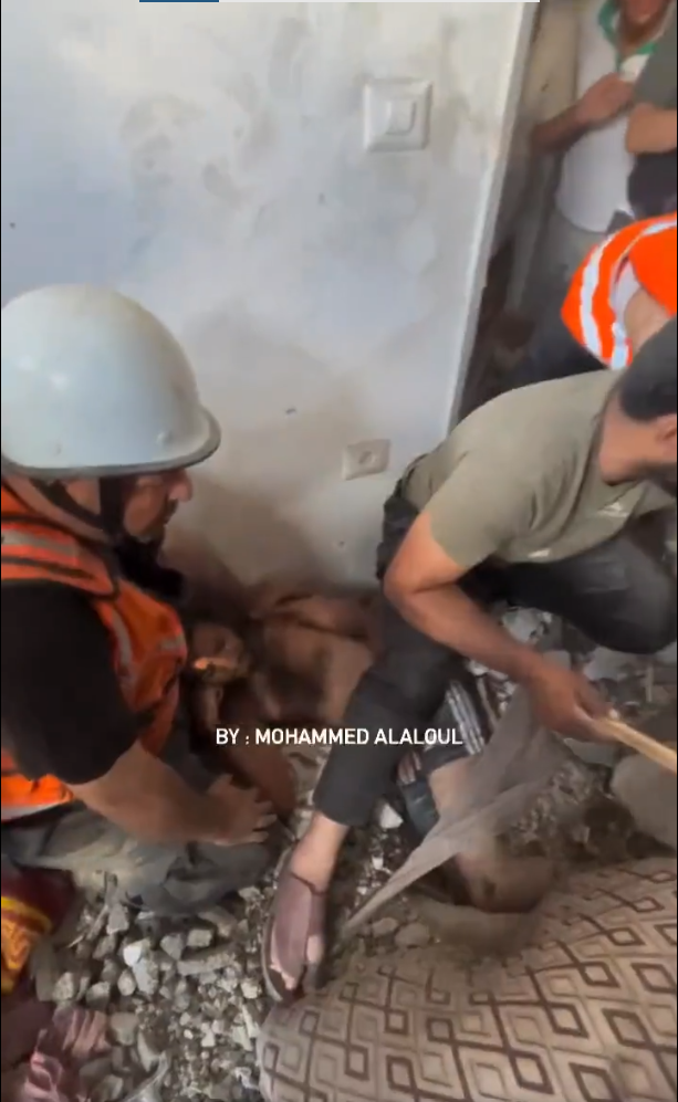 Civil Defense Forces rescue a Palestinian youth who was stuck under the rubble of his home after being bombed by Israeli air strikes in Gaza