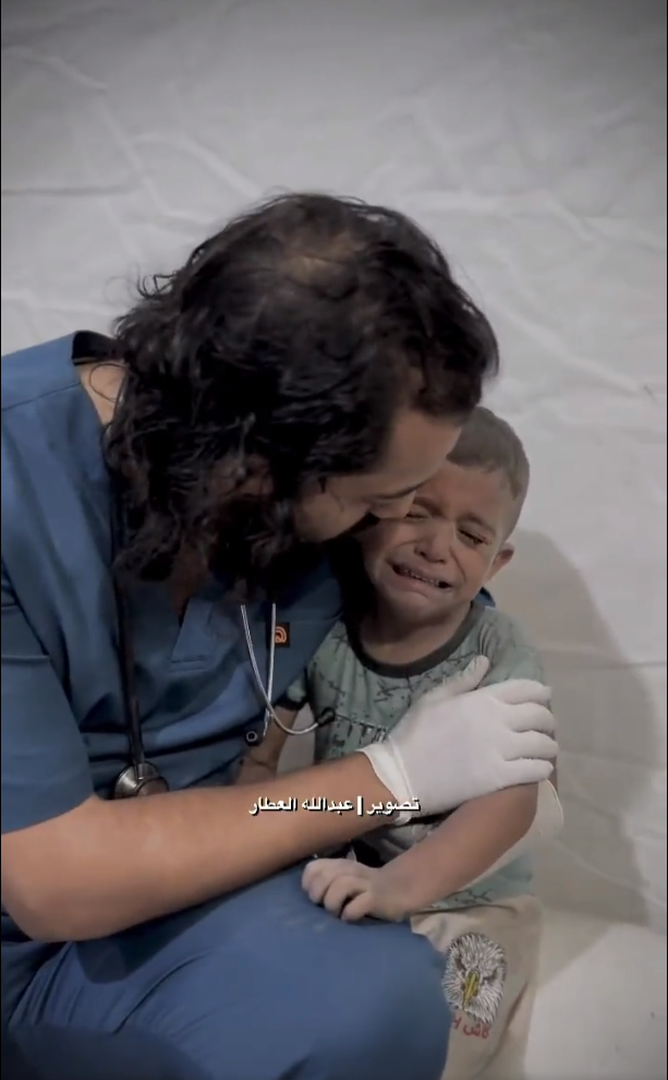 A Doctor embraces a child and tries to calm him down whilst he was shaking from fear in one of the hospitals in Gaza